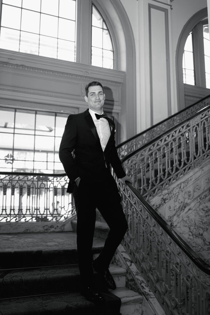 Groom posing on the grand staircase at the Omni Severin.