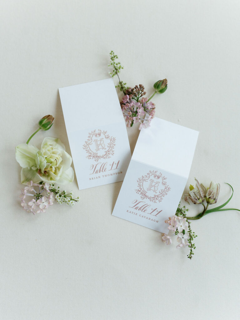 Escort cards designed by Empress Stationery, with floral crest and calligraphy script